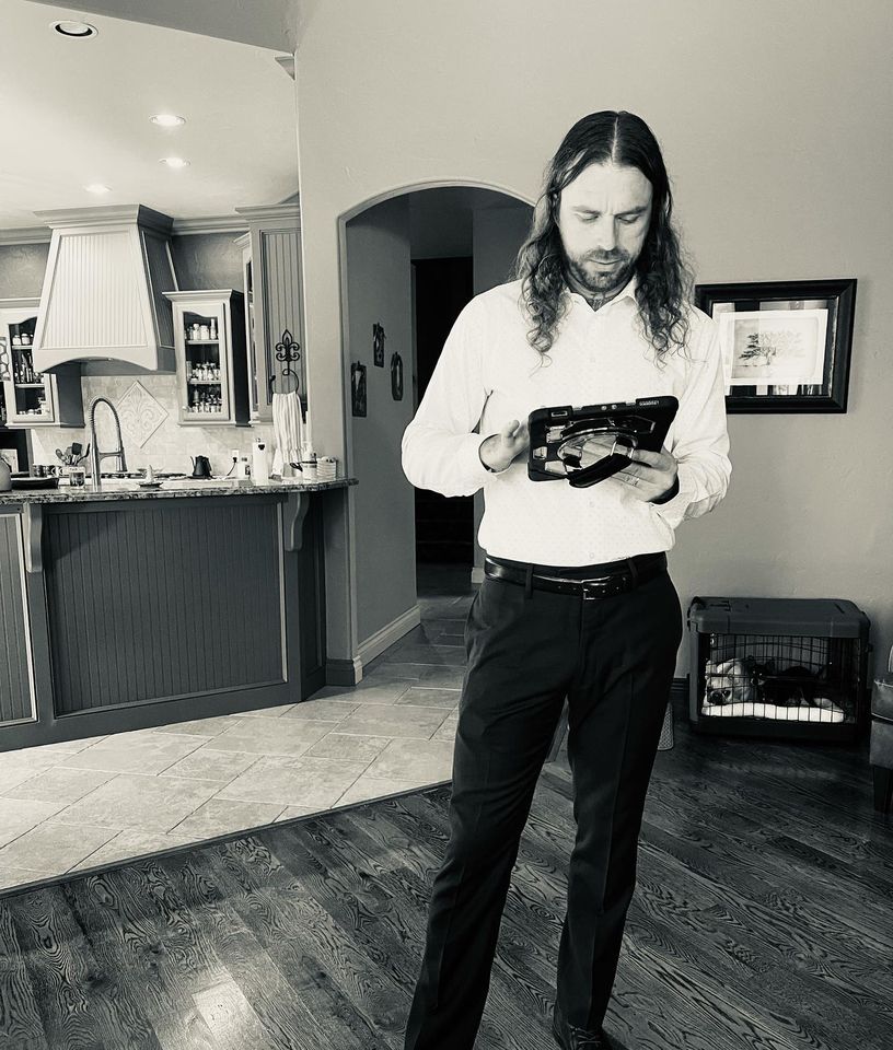 black and white of man in home holding ipad giving a full service moving quote
