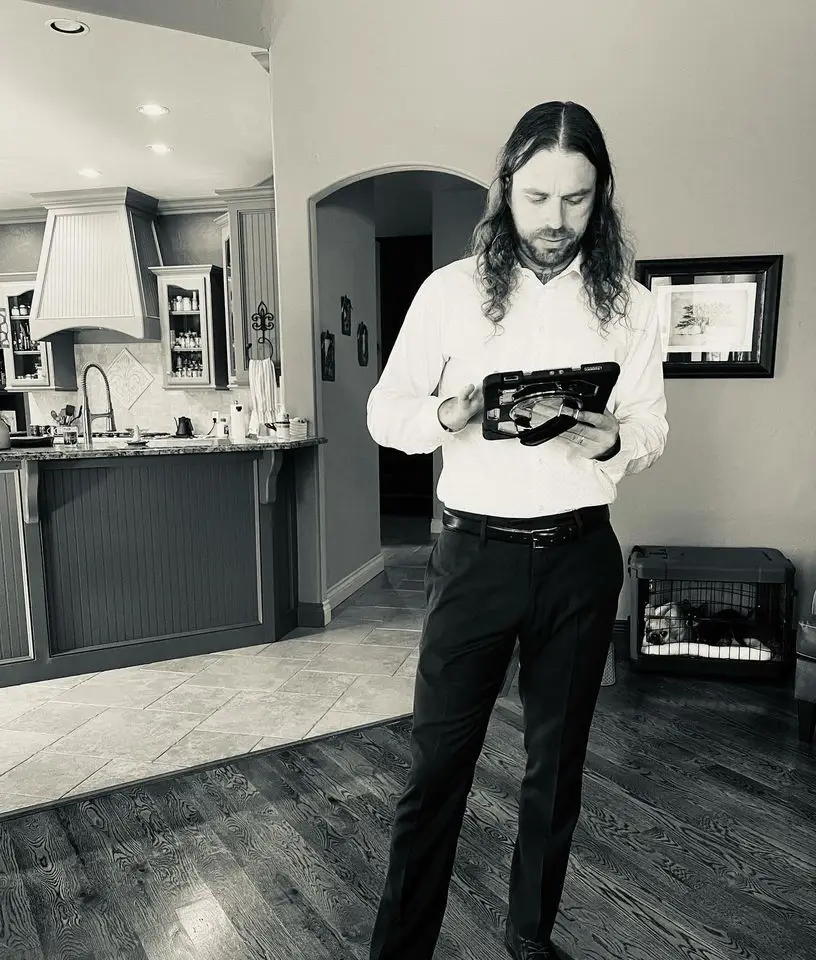 black and white of man in home holding ipad giving a full service moving quote